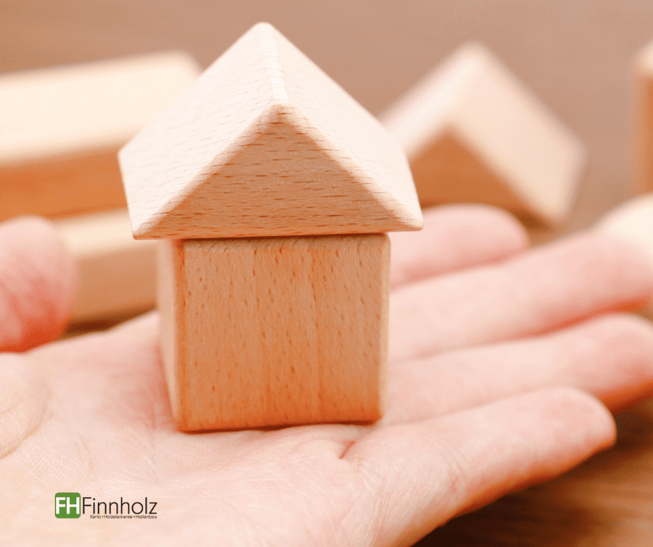 Modulbau FH Finnholz: Hand mit Miniaturhaus