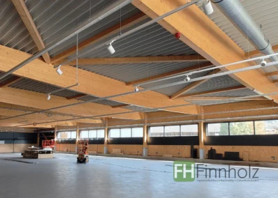 Einzelhandelsgeschäft in Rotenburg an der Fulda - Bild 2: Dargestellt ist eine Innenaufnahme der Holzhalle. Die Tragstrukturen aus Holz sind gut zu erkennen. Diese kommen mit wenigen Stützen aus, was mehr Platz für Einkaufsflächen bietet.