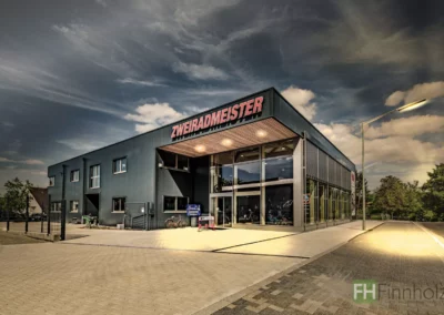 Gewerbehalle mit Ausstellungsbereich in Waldbröl bei beleuchtetem Eingangsbereich am Abend.