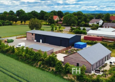 Luftaufnahme des Holzbauprojekts in Stemwede mit Halle, Wohnhaus und Carport.