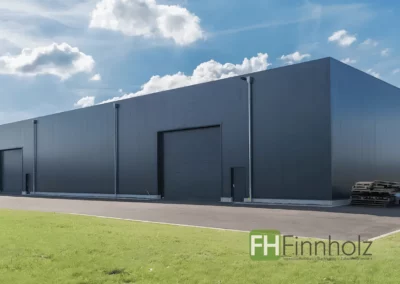 Außenansicht der Produktionshalle mit Büro in Lage mit großer Hallenfläche und zwei Rolltoren.