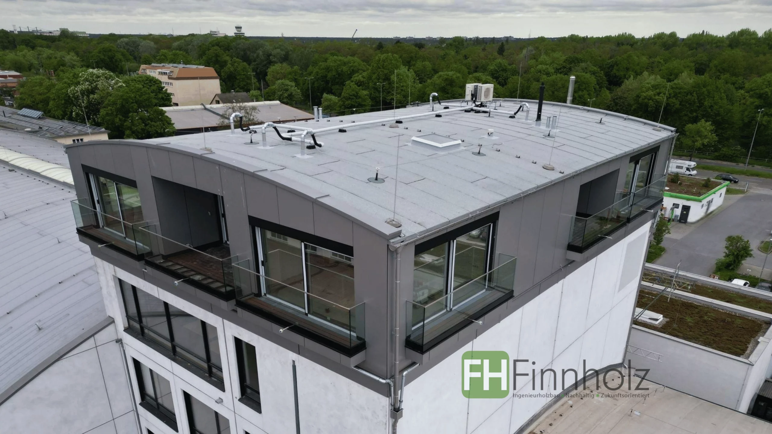 Wohnungsaufstockung Berlin - Bild 1 Das Bild zeigt die Wohnungsaufstockung Berlin im EH-40-Standard im 5. OG. Die Alu-Fassade ist deutlich zu erkennen. Die Aufstockung verfügt über viele Fenster und sogar über Balkone.