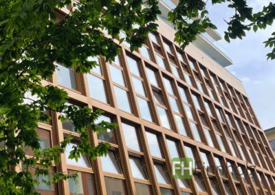 Seitenansicht unserer Aufstockung in Holzbauweise in Hagen mit Fokus auf die neue Fassade mit zahlreichen Fenstern.
