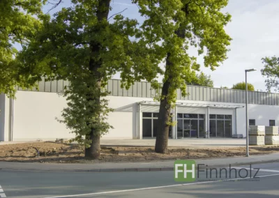 Frontansicht der Einzelhandelshalle in Holzbauweise in Bielefeld mit separatem Vordach.