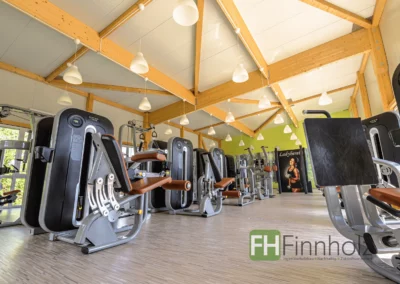Trainingsbereich im Fitnessstudio in Wegberg mit Fitnessgeräten und sichtbarer Holzkonstruktion.