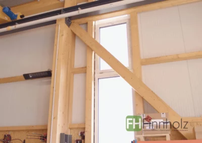 Innenansicht der Industriehalle mit 10-Tonnen-Kranbahn auf Holzstützen.