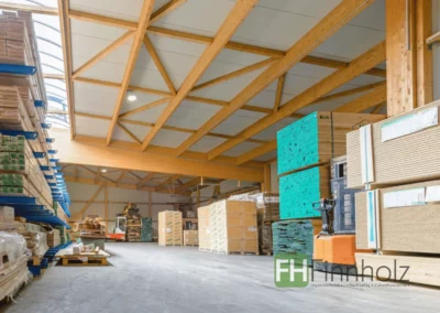 Stützenfreie Lagerfläche in Ellerau mit weit gespannter Holzkonstruktion und gelagerten Baumaterialien.